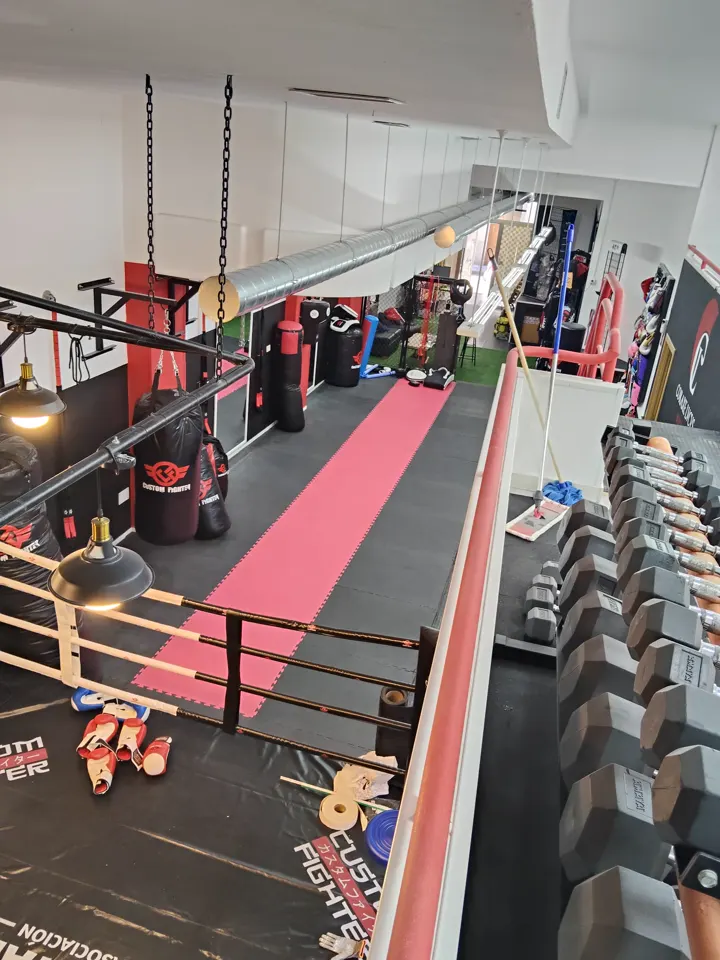 La sala: el pasillo de tatami, los sacos colgados y el estante de mancuernas
